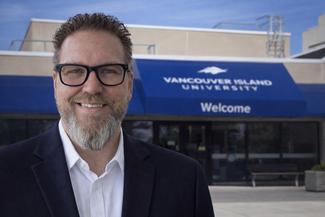 Executive leader standing in front of the Vancouver Island University welcome centre