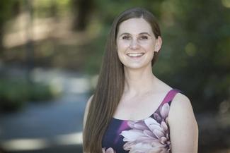 Person with brown hair standing for a headshot