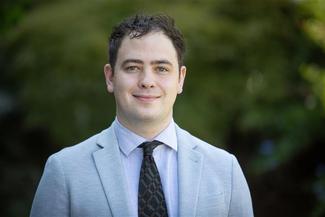 Man smiling at a camera for a headshot